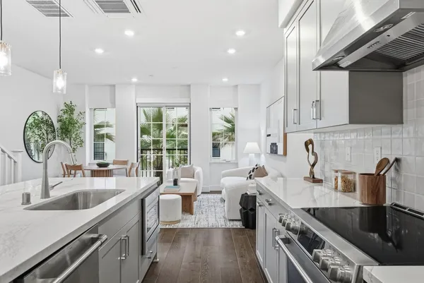 a kitchen with stainless steel appliances a sink a stove and a wooden floors