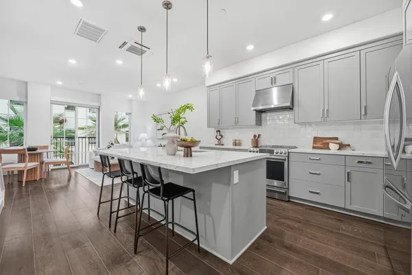 a kitchen with a sink window and chairs