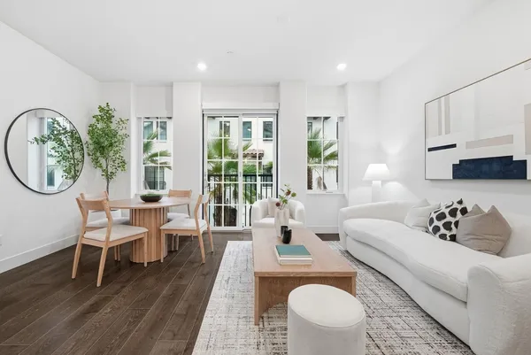 a living room with furniture a table and a large window