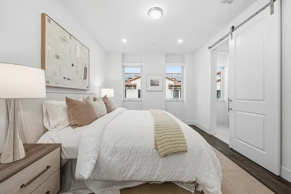 a bed room with a bed and a refrigerator