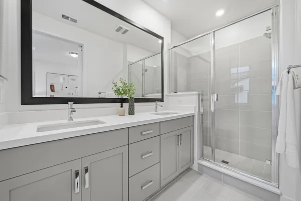 a bathroom with a shower sink and mirror