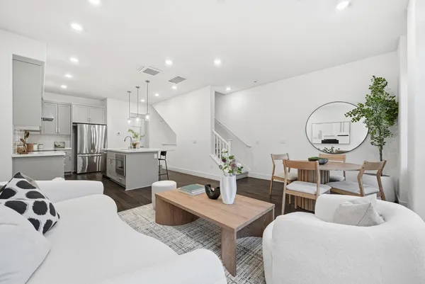 a living room with furniture kitchen view and a large mirror