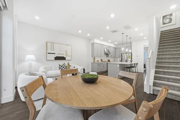 a kitchen with stainless steel appliances kitchen island granite countertop a table and chairs in it