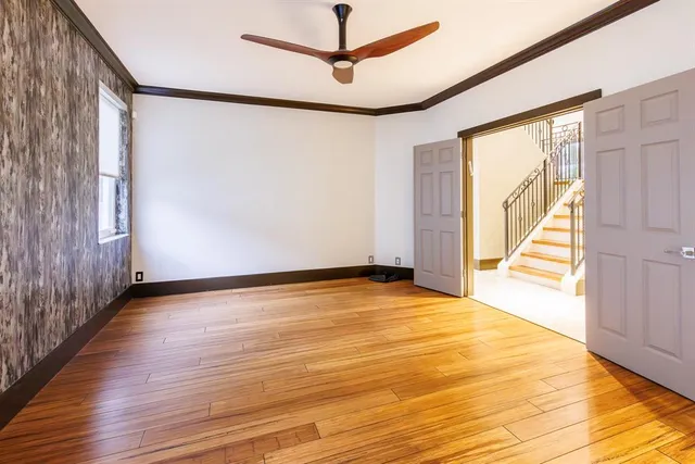 a view of an empty room with wooden floor and a window