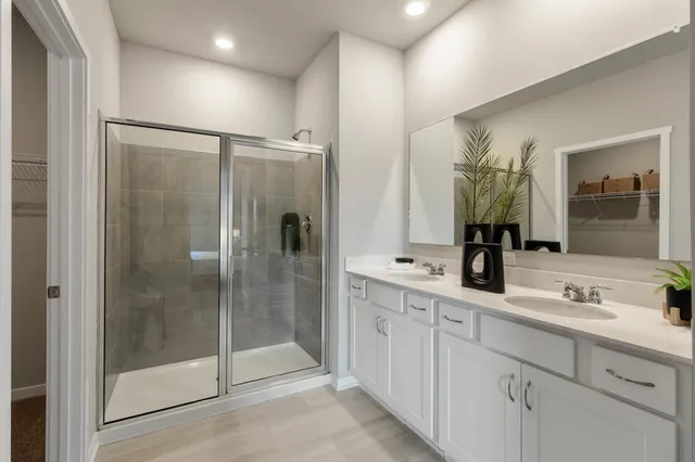 a bathroom with a double vanity sink mirror and shower