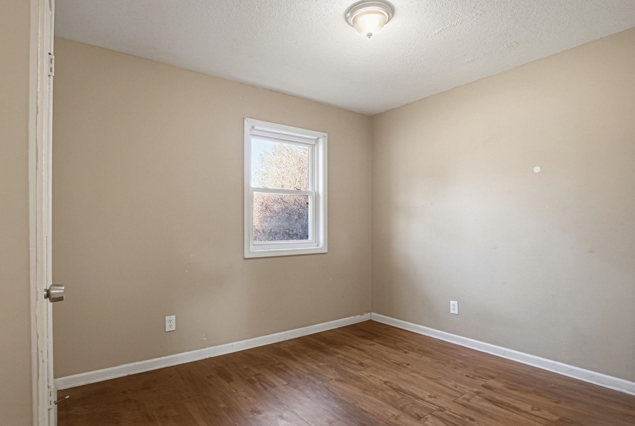 4562 Tulane Road Memphis, TN 38109 - Photo 27 of 32 Wood-finish flooring, neutral wall tones, and a window with white trim