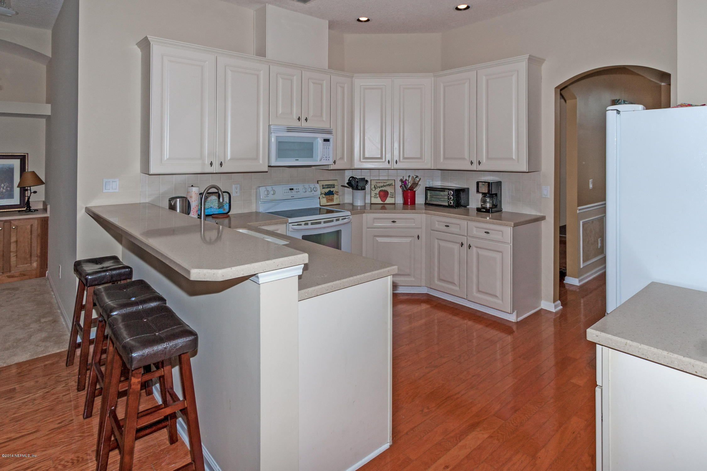 773 West Devonhurst Lane Ponte Vedra, FL 32081 - Photo 6 of 16 a kitchen with stainless steel appliances a stove top oven a sink a refrigerator white cabinets and wooden floor