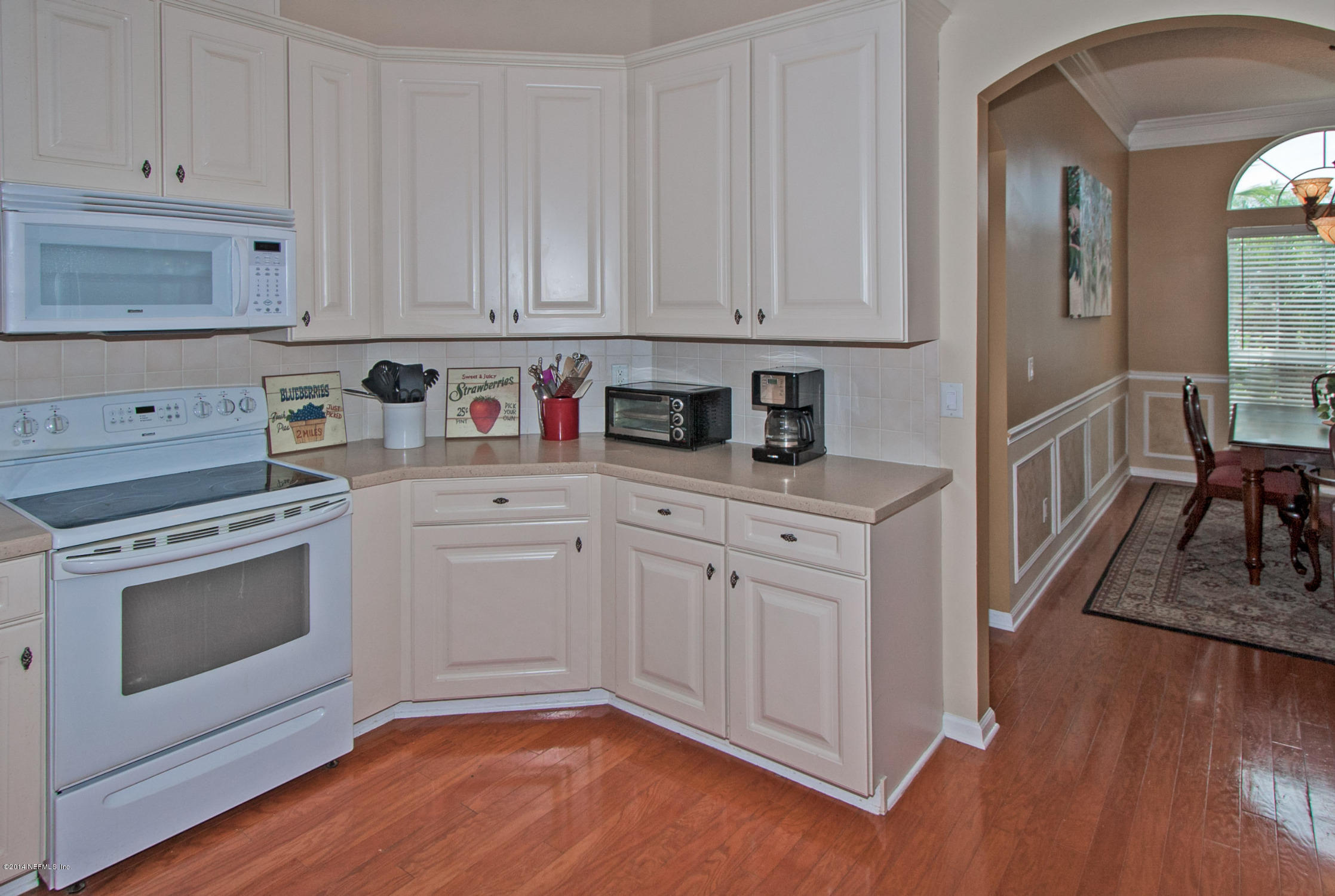 773 West Devonhurst Lane Ponte Vedra, FL 32081 - Photo 8 of 16 a kitchen with stainless steel appliances granite countertop a stove a sink and a white cabinets with wooden floor