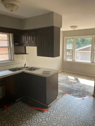 a kitchen with stainless steel appliances kitchen island granite countertop a sink stove and cabinets