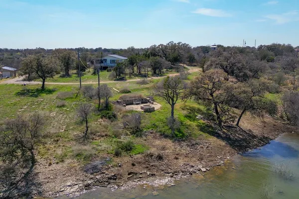 a view of dirt yard with large trees