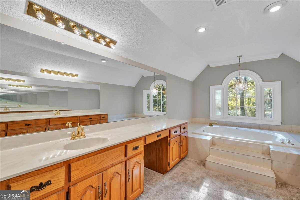 1015 Cherokee Road Perry, GA 31069 - Photo 31 of 71 a spacious bathroom with a granite countertop tub a double vanity sink and a window