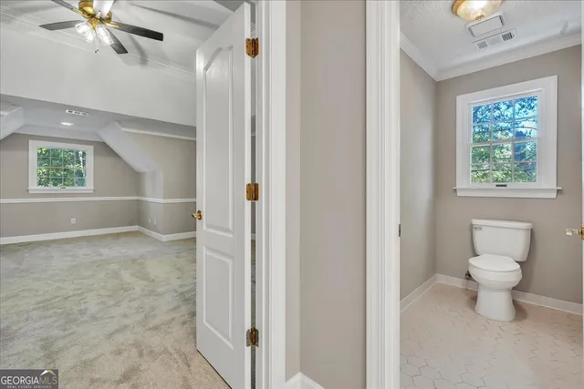 an empty room with a chandelier fan and windows