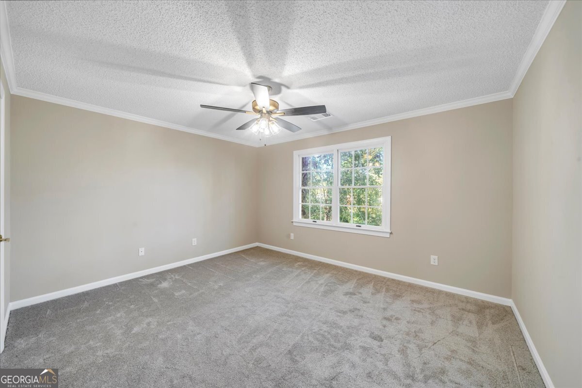 1015 Cherokee Road Perry, GA 31069 - Photo 42 of 71 an empty room with a chandelier fan and windows