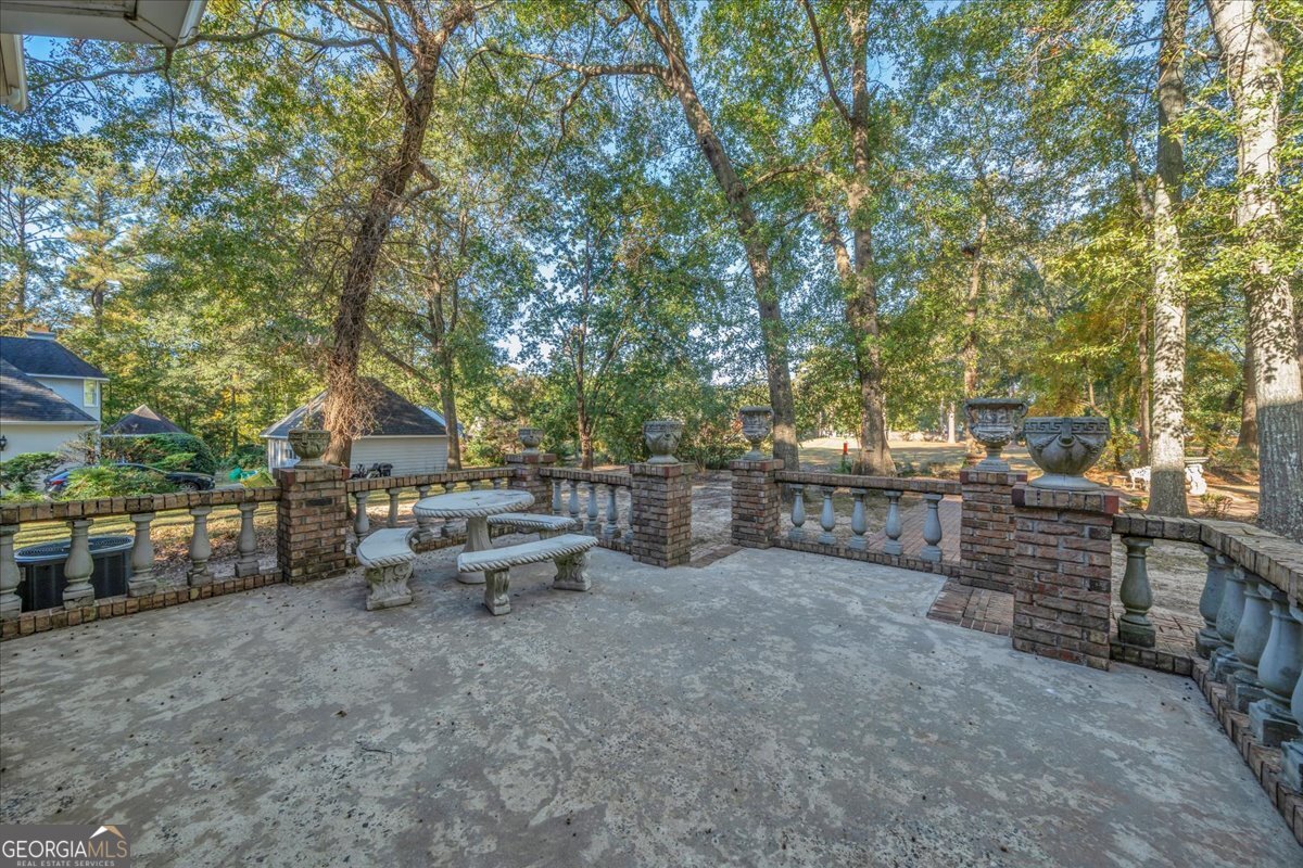 1015 Cherokee Road Perry, GA 31069 - Photo 46 of 71 a view of a patio with table and chairs potted plants and large tree