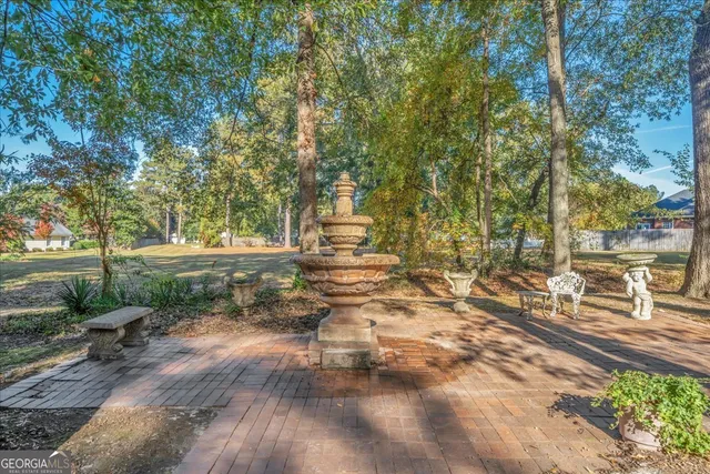 a view of a brick house with many windows next to a yard