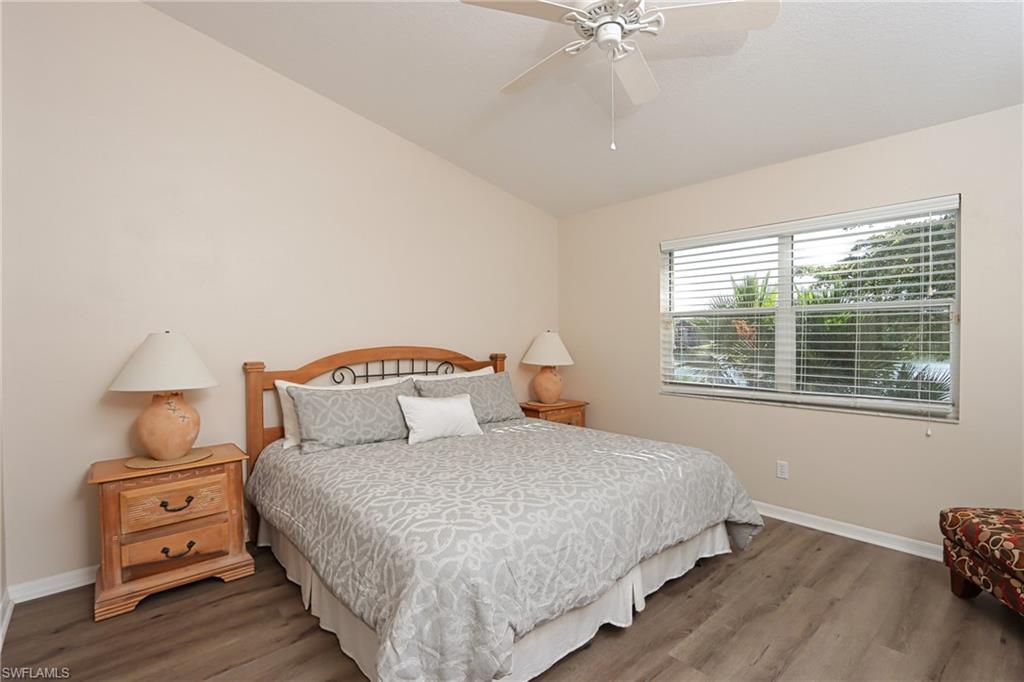 6544 Huntington Lakes Circle, Unit 9204 Naples, FL 34119 - Photo 12 of 31 a bedroom with a bed and wooden floor