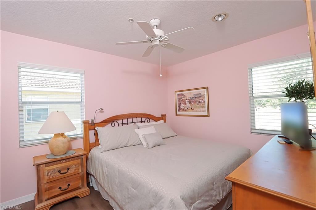 6544 Huntington Lakes Circle, Unit 9204 Naples, FL 34119 - Photo 15 of 31 a bedroom with a bed and a desk