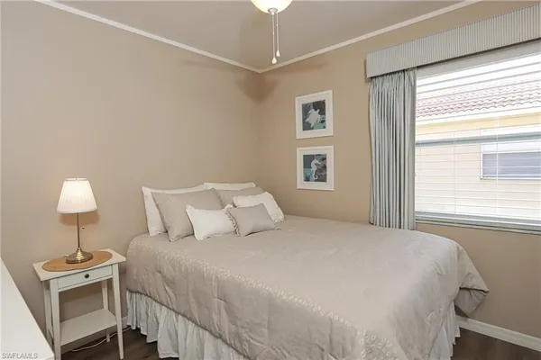 a bedroom with a bed and a lamp on dresser