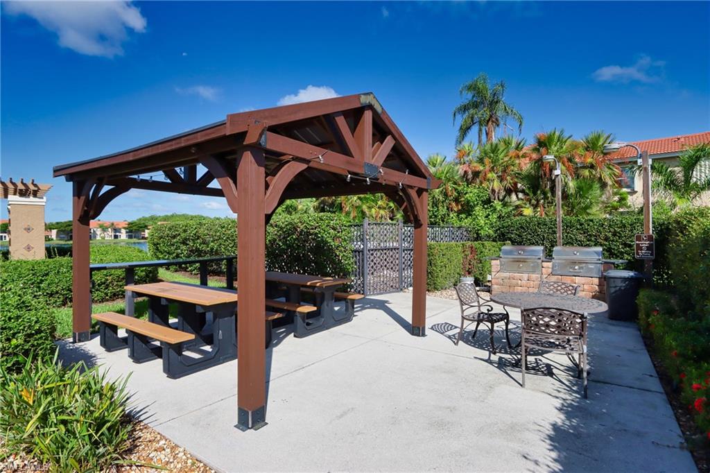 6544 Huntington Lakes Circle, Unit 9204 Naples, FL 34119 - Photo 25 of 31 a patio with table and chairs