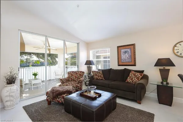 a living room with furniture a flat screen tv and a floor to ceiling window