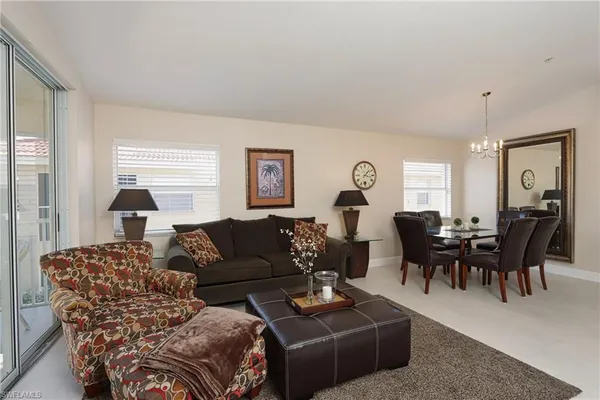 a living room with furniture a large window and a table