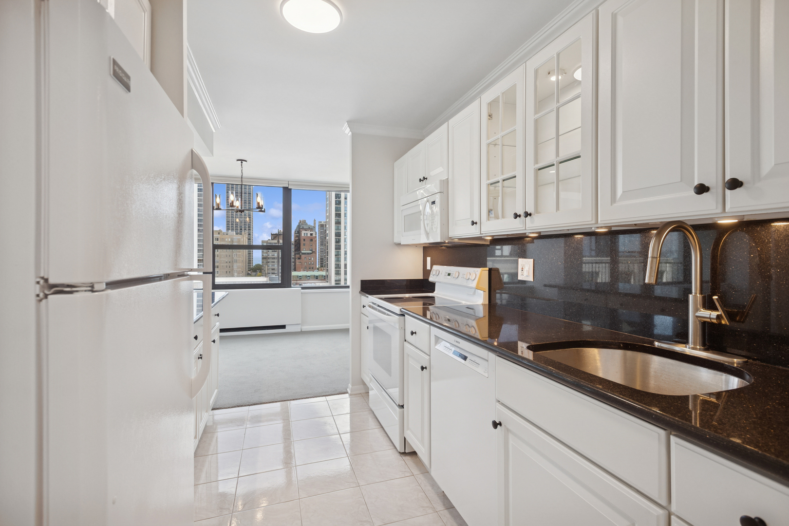 1560 North Sandburg Terrace, Unit 1412 Chicago, IL 60610 - Photo 5 of 16 a kitchen with stainless steel appliances granite countertop a sink stove and cabinets