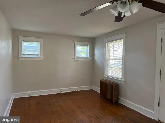 a view of a room with wooden floor and windows