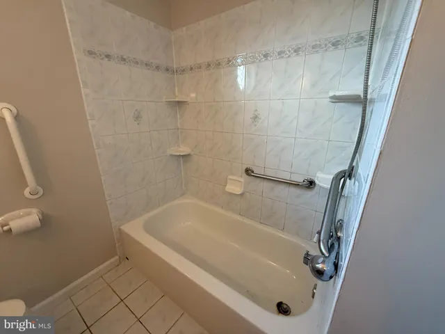 a white bath tub sitting next to a white sink and vanity