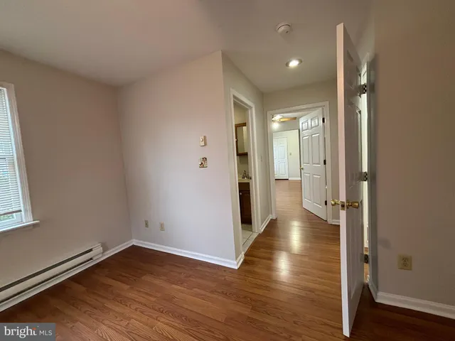 a view of a hallway with wooden floor