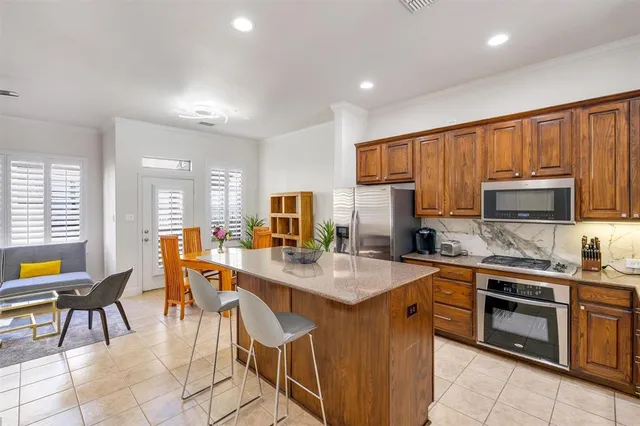 a kitchen with a sink a center island cabinets and stainless steel appliances
