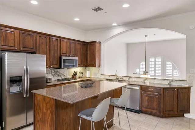 a kitchen with granite countertop a sink stainless steel appliances and counter space