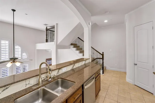 a kitchen with granite countertop a sink a stove and a refrigerator