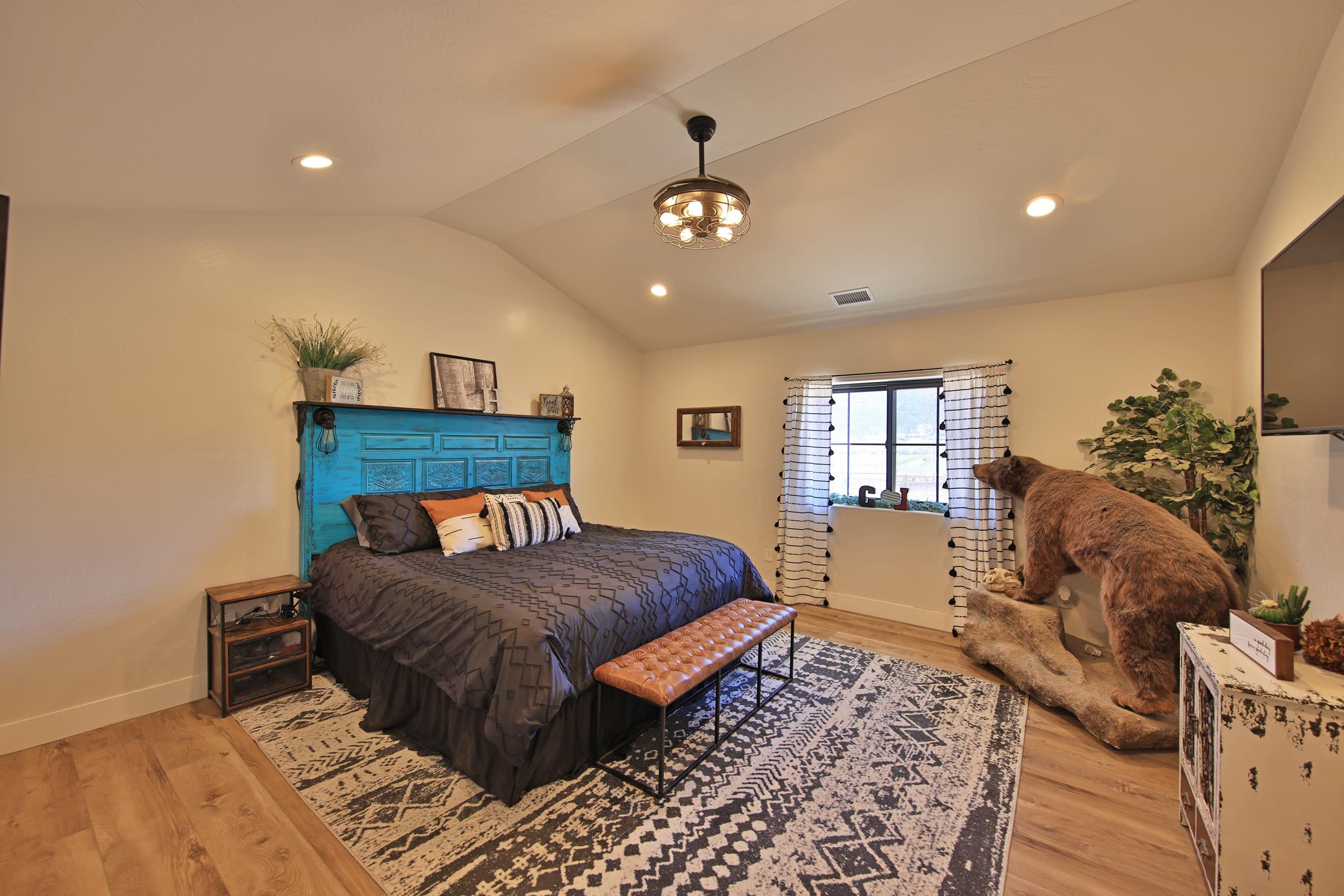58749 Oe Road Collbran, CO 81624 - Photo 14 of 42 a bedroom with a large bed and a chandelier