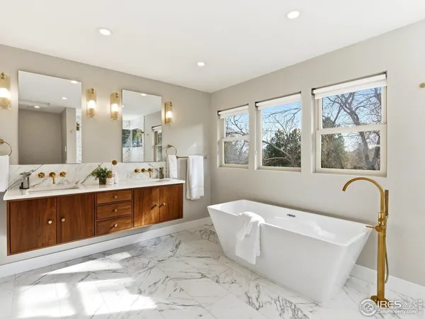 a spacious bathroom with a tub sink and mirror