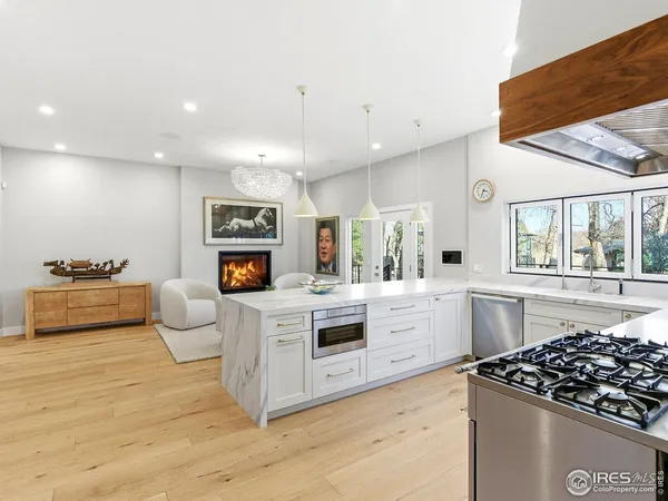 a kitchen with stainless steel appliances a white stove top oven and white cabinets