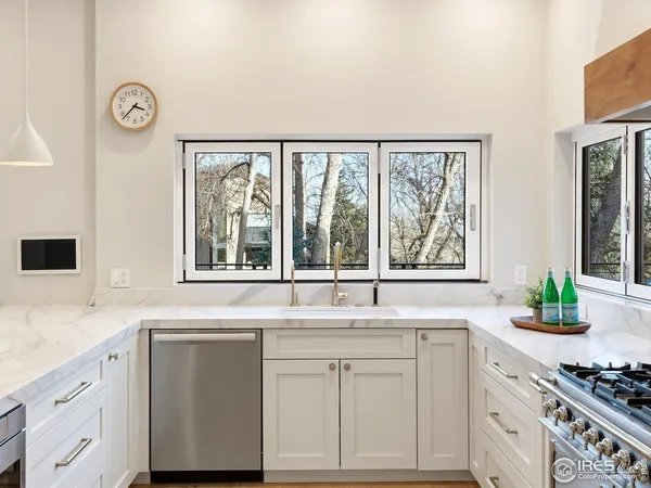 a kitchen with stainless steel appliances white cabinets and a window