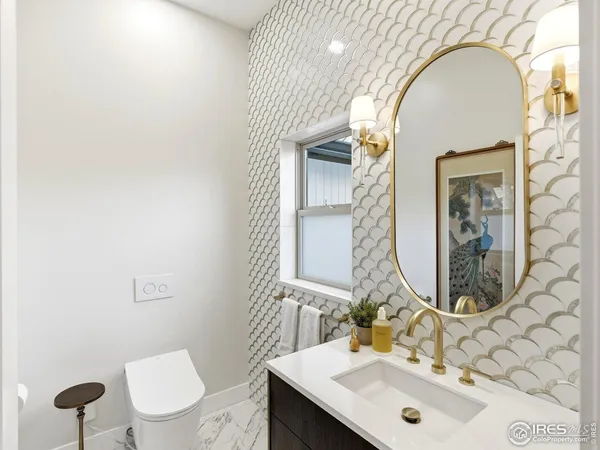 a bathroom with a sink a toilet and mirror