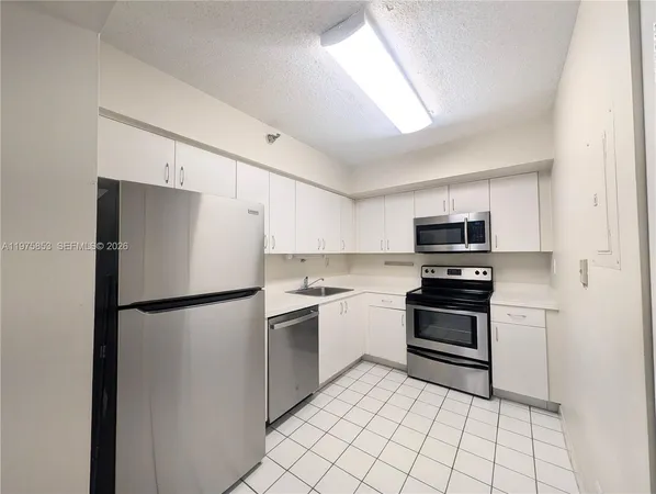a kitchen with stainless steel appliances a refrigerator sink and stove