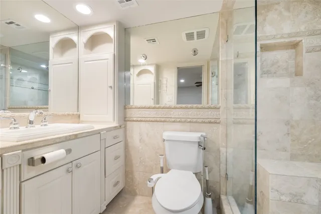 a bathroom with a toilet a sink a mirror and vanity