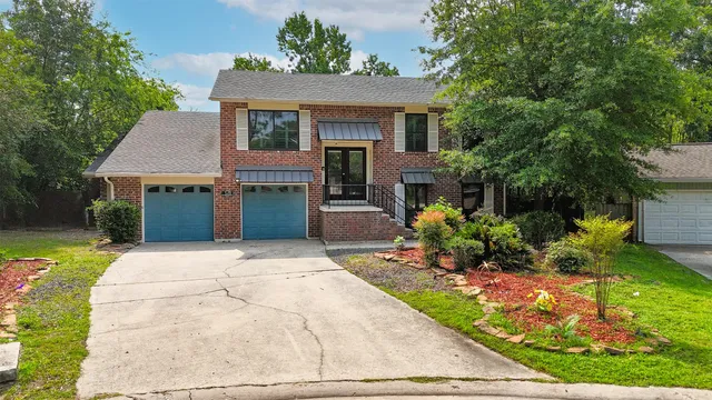 a front view of a house with a garden and plants