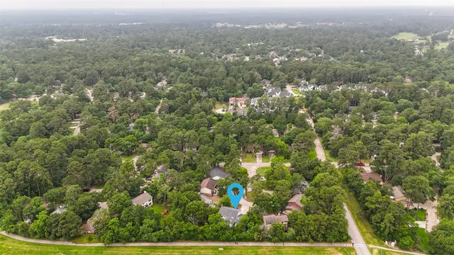 an aerial view of residential houses with outdoor space and trees