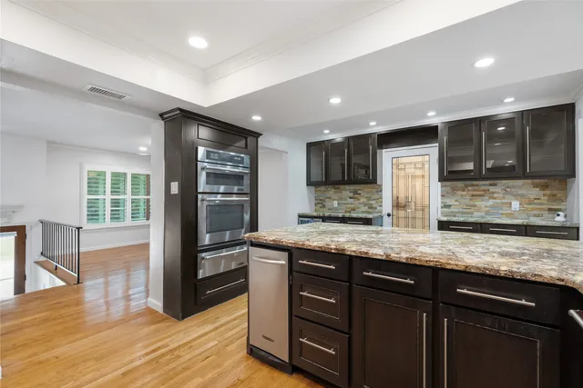 a kitchen with stainless steel appliances granite countertop a stove a sink and a refrigerator