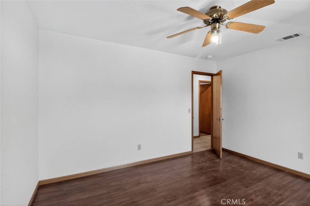 18539 Symeron Road Apple Valley, CA 92307 - Photo 18 of 30 an empty room with wooden floor and fan