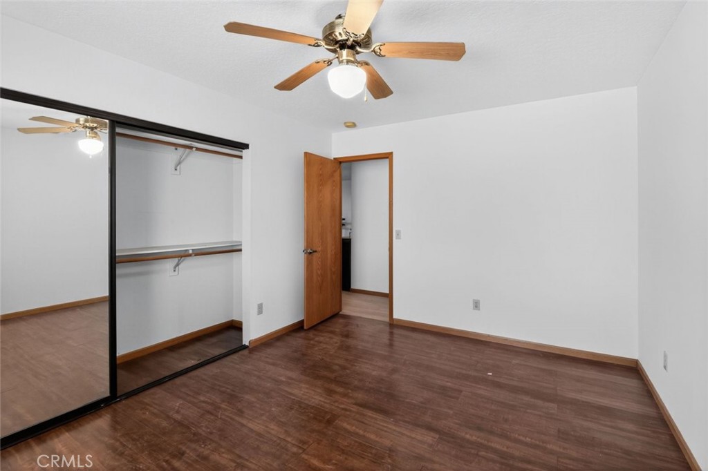 18539 Symeron Road Apple Valley, CA 92307 - Photo 25 of 30 an empty room with wooden floor closet and ceiling fan