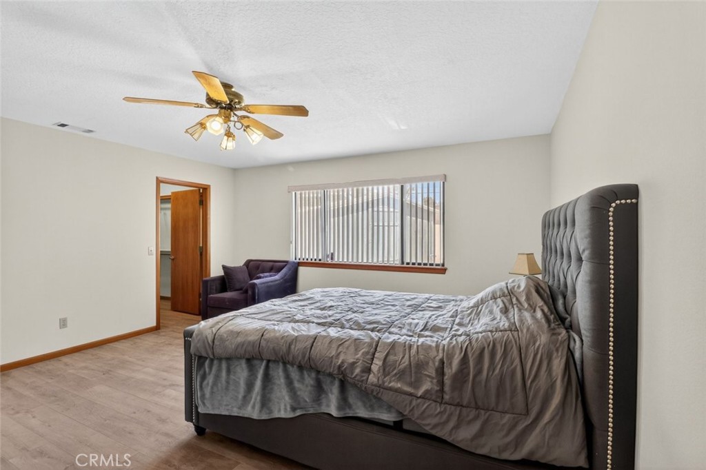 18539 Symeron Road Apple Valley, CA 92307 - Photo 27 of 30 a bedroom with a bed and a chandelier