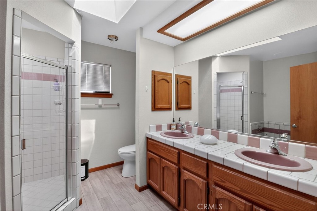 18539 Symeron Road Apple Valley, CA 92307 - Photo 29 of 30 a bathroom with a double vanity sink toilet and shower