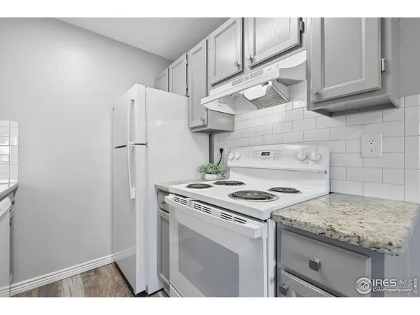 a kitchen with stainless steel appliances granite countertop a stove a refrigerator and a cabinets