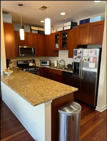 a kitchen with stainless steel appliances granite countertop wooden cabinets and a refrigerator