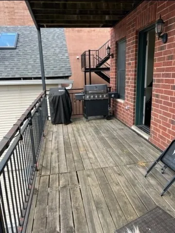 a view of a balcony with wooden floor and iron stairs