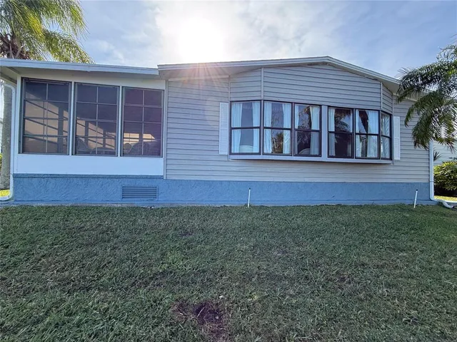 a view of a backyard with lawn chairs under an umbrella
